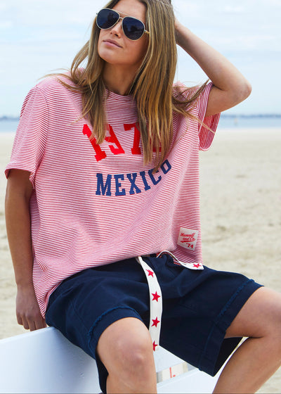 Hammill & Co tee is a total throwback in the best way. With fine red and white stripes and a pop of red and navy “1976 MEXICO” across the front.