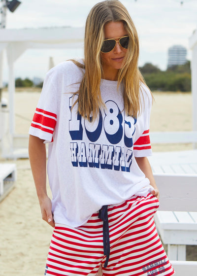 Hammill & Co White slouchy tee with navy 1985 print on the front and red stripes on each sleeve. Our standard over size fit, the same as our logo tees.
