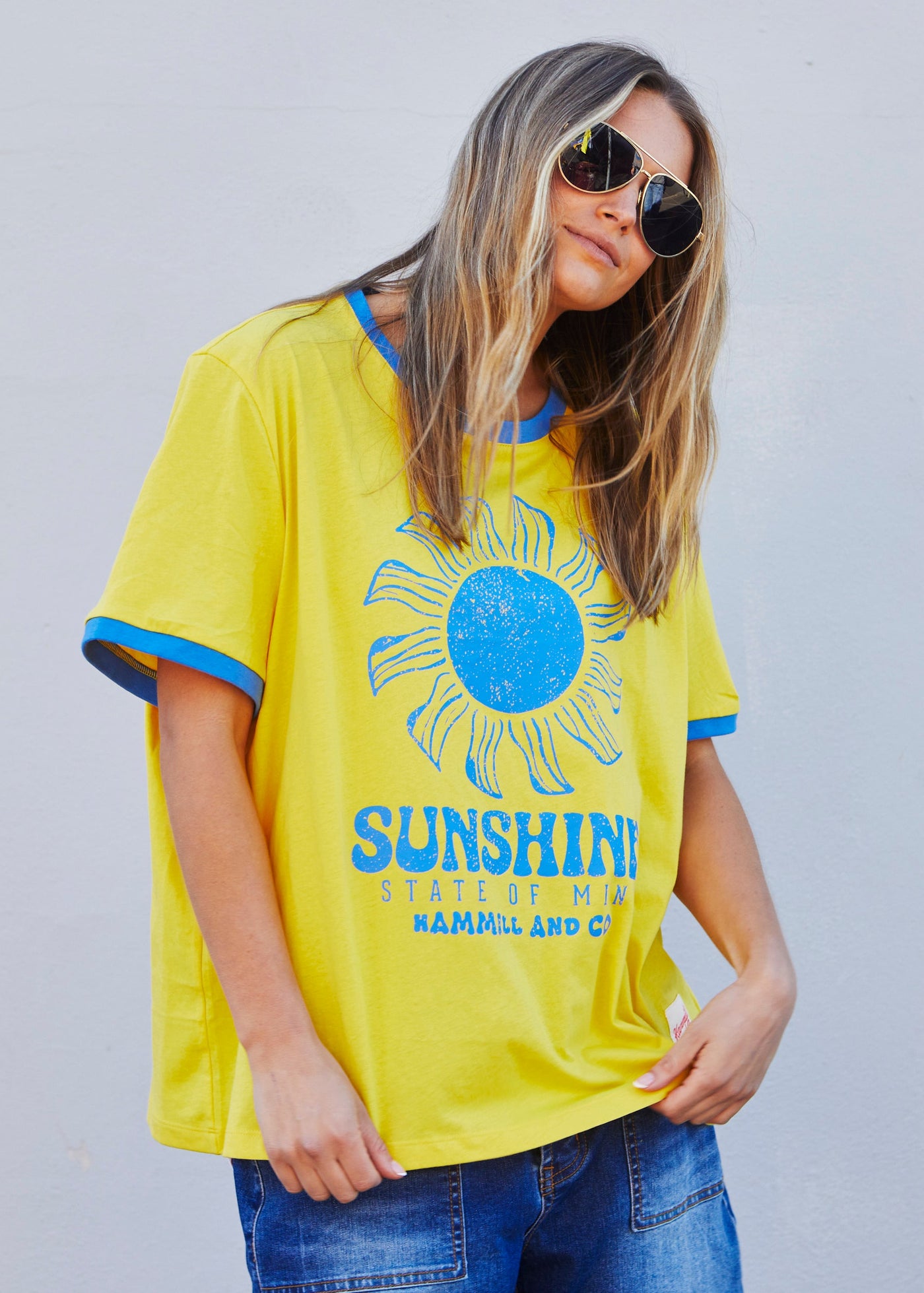 Hammill & Co Sunshine State of Mind tee in a slouchy V neck style in a soft bright yellow slub jersey with royal blue print on the front .