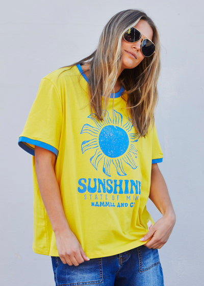 Hammill & Co Sunshine State of Mind tee in a slouchy V neck style in a soft bright yellow slub jersey with royal blue print on the front .