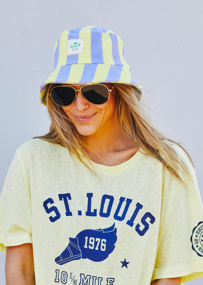 Hammill & Co bold striped bucket hat is pure summer happiness. Made from soft terry towelling in vibrant mauve/lemon stripes, it adds a playful pop to any outfit. 